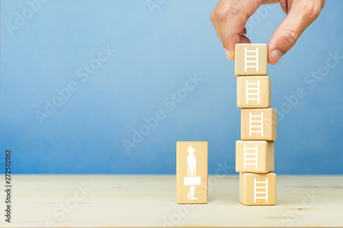 Development business growth success concept, Hand of businessman arranging wooden blocks with stair icons on blue background, Copy space