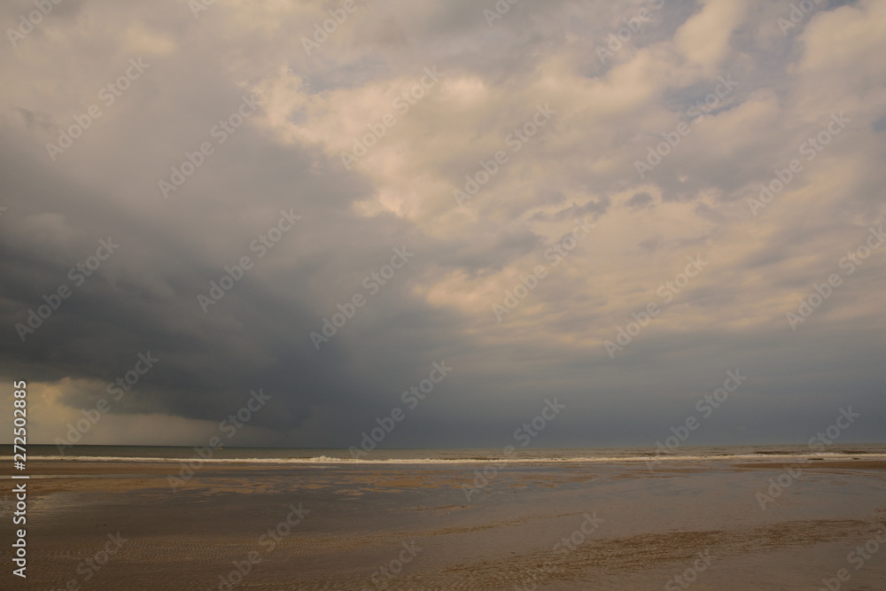 Plażą nad morzem w pochmurny dzień pod niebem z chmurami. Plażą nad morzem w pochmurny dzień pod niebem z chmurami.