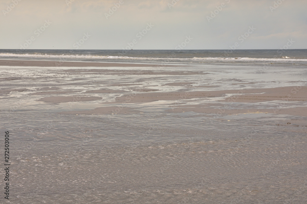Plażą nad morzem w pochmurny dzień pod niebem z chmurami. Plażą nad morzem w pochmurny dzień pod niebem z chmurami.