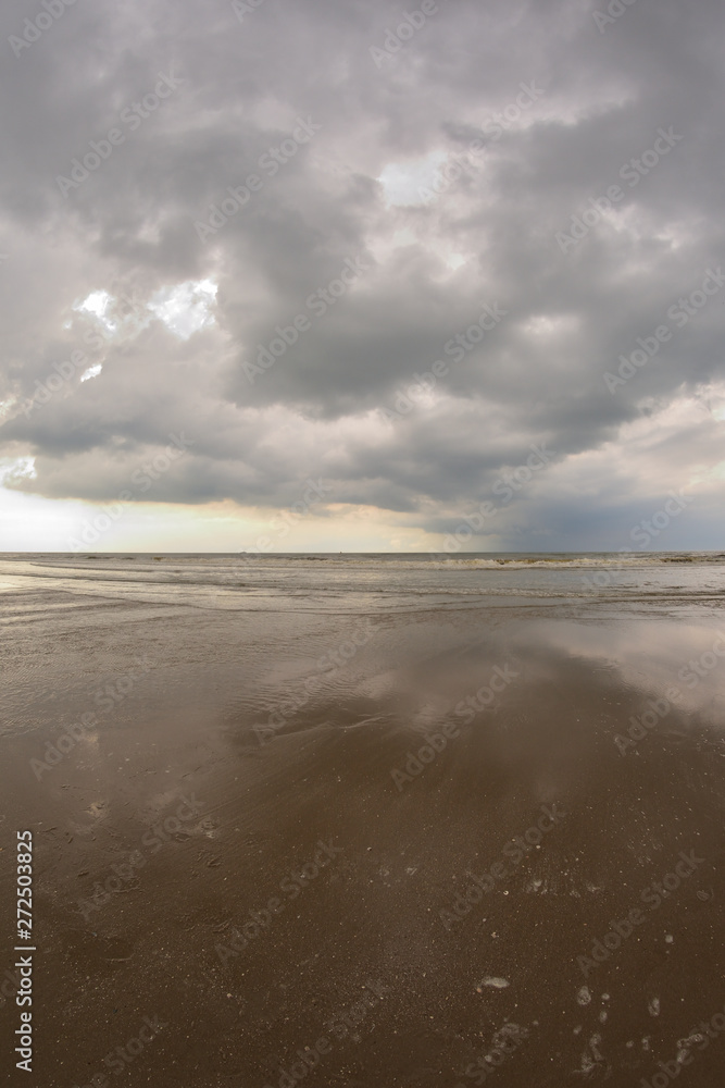 Plażą nad morzem w pochmurny dzień pod niebem z chmurami. Plażą nad morzem w pochmurny dzień pod niebem z chmurami.