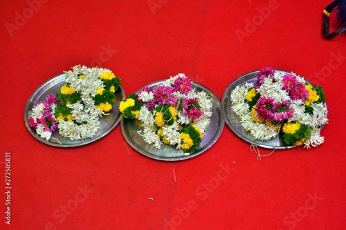 Maharashtrian Wedding Ritual - Seeman Puja - Closeup of plates (Thali)  decorated with garlands (Mundavalya) for Groom and Bride. photo