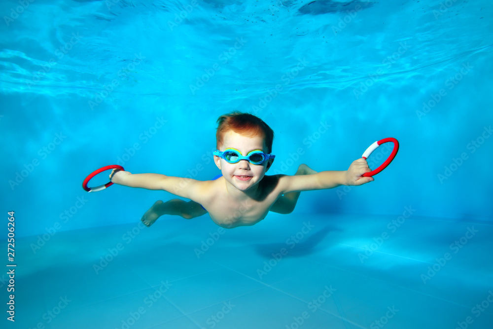 © alexbard - Sporty little boy swimming underwater in the pool with toys in his hands. Portrait. Close up. Underwater photography. Horizontal orientation © alexbard - Sporty little boy swimming underwater in the pool with toys in his hands. Portrait. Close up. Underwater photography. Horizontal orientation