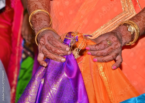 Maharashtrian Wedding Ritual - Gathbandan - Brides sister tying knot of Bride and Grooms clothes.The couple walks around the fire, the bride leading, and take solemn vows of loyalty, steadfast love