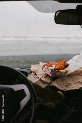 eating fish and chips to go in car on the beach photo