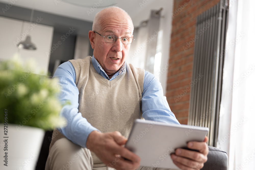 Smiling senior man using a digital tablet Smiling senior man using a digital tablet