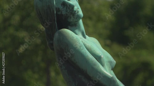 Beautiful female statue in luscious garden