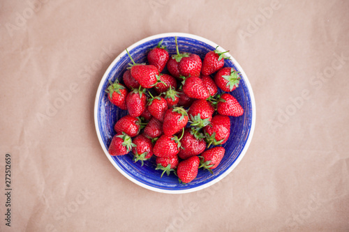 Bright blue dish with ripe strawberries. View from above. Concept of summer mood and healthy eating.