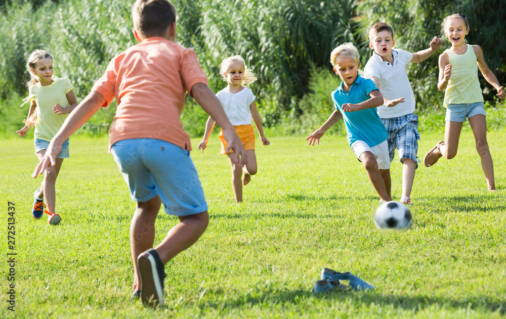 Obraz premium kids kicking football in park