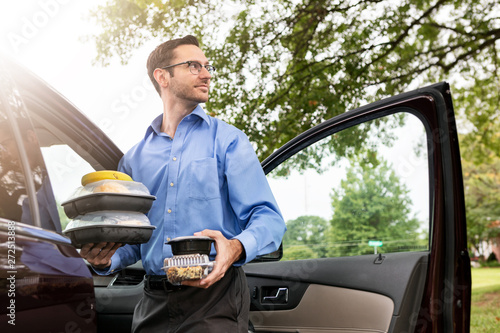 Meal: Businessman Delivering Meals To Senior On Lunch Break photo