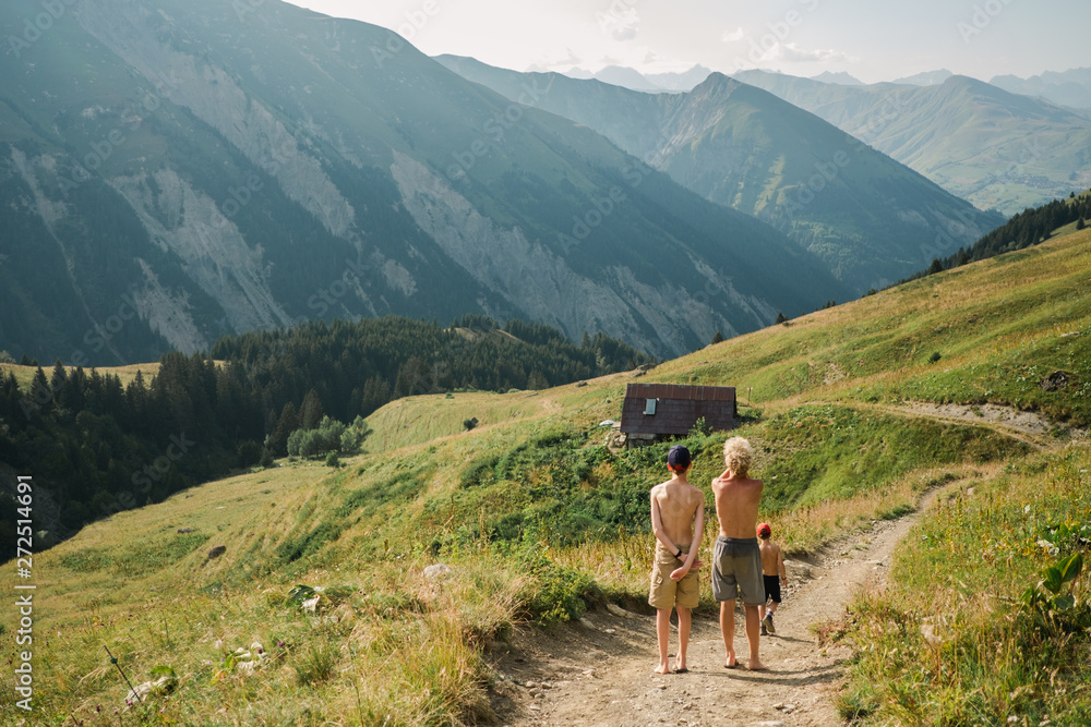three boys walking on path towards their hut, in the Alps, France. three boys walking on path towards their hut, in the Alps, France.