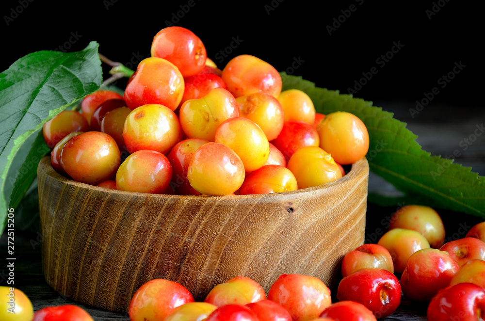 Sweet cherry in a wooden bowl on a wooden table. Sweet cherry in a wooden bowl on a wooden table.