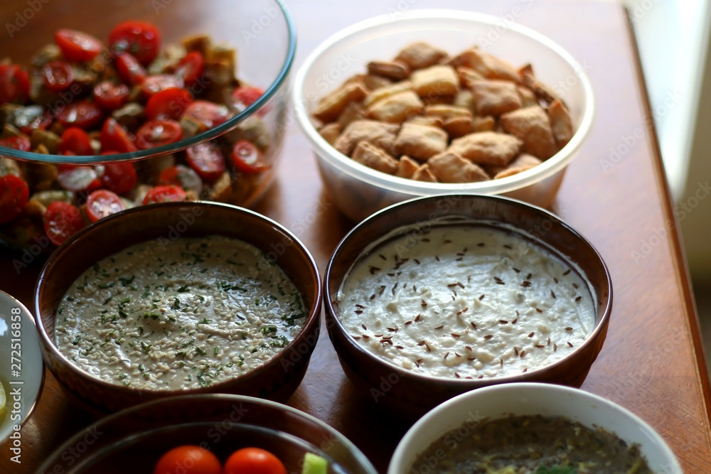 Table setting with galette, snacks, dips and salads. Selective focus. Table setting with galette, snacks, dips and salads. Selective focus.