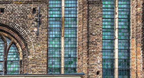 Exterior with stained glass windows of medieval Sint-Janshospitaal (St John’s Hospital), founded in the mid-12th century. Cityscape of Bruges streets shot from the boat.
