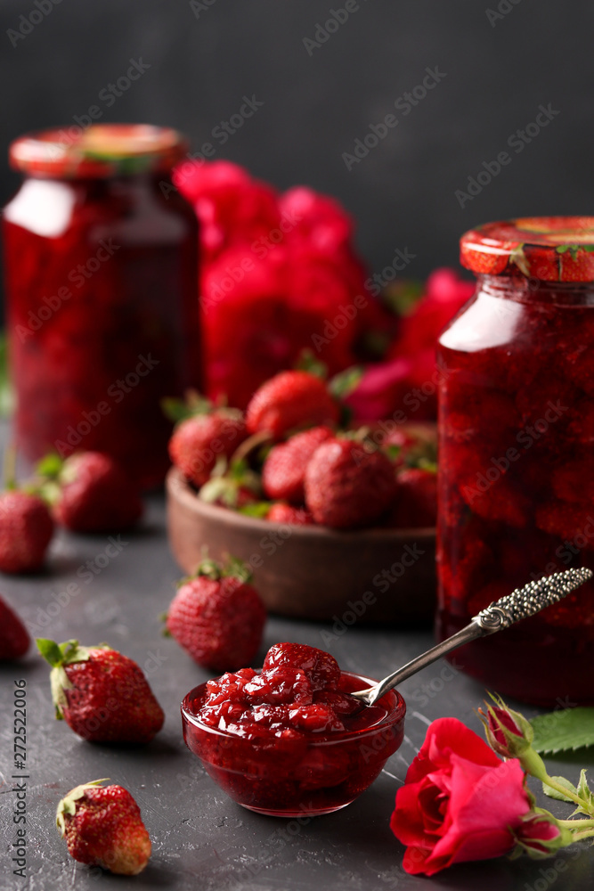 Strawberry jam in a can and fresh strawberries on a dark background, summer harvest Strawberry jam in a can and fresh strawberries on a dark background, summer harvest