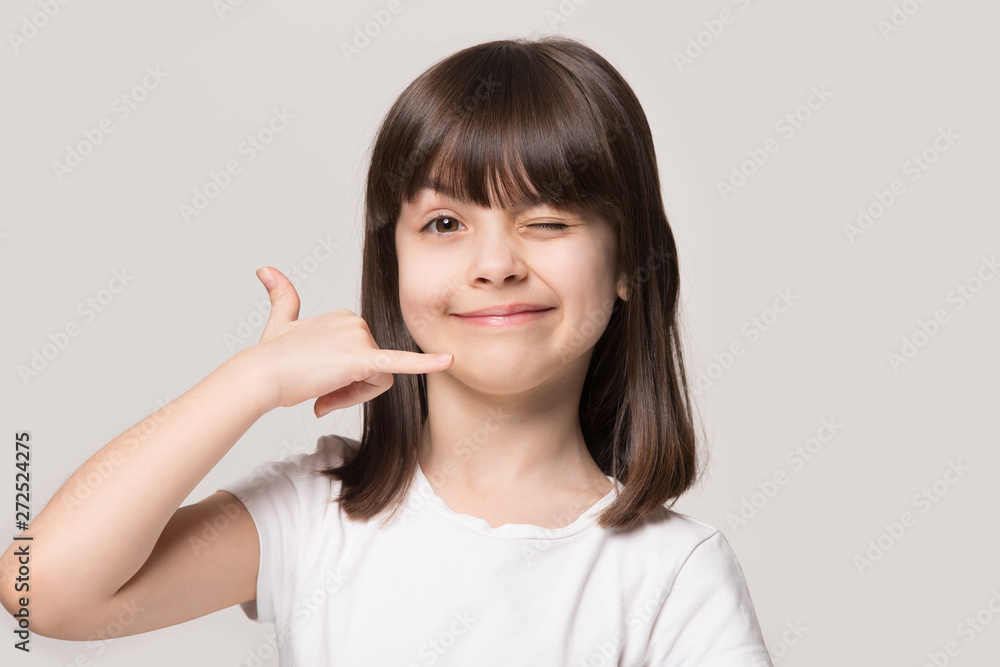 Little funny girl makes call me hand gesture studio shot Little funny girl makes call me hand gesture studio shot