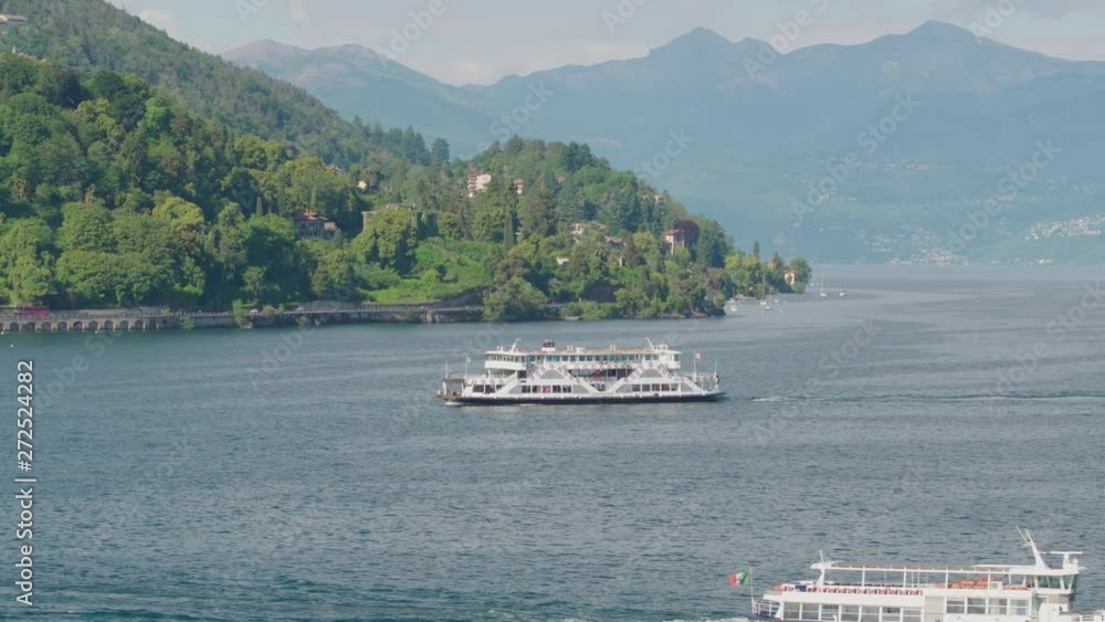 Aerial view of two ferrys sailing in the lake maggiore with the mountains behind transporting tourists to the borromean islands. Aerial view of two ferrys sailing in the lake maggiore with the mountains behind transporting tourists to the borromean islands.