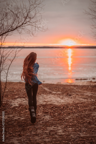 Woman enjoying time relaxing by the beautiful lake at sunrise.