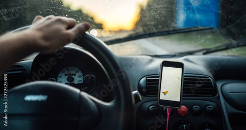 travel driving a car in the summer, the navigator in the smartphone. the driver is driving