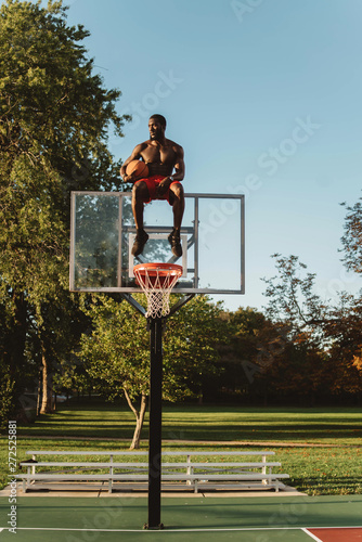 An attractive young black man playing basketball o on a sunny day photo