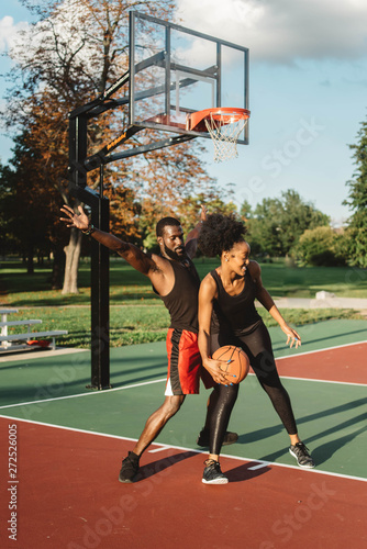 An Attractive African American Couple playing basketball on a sunny day photo