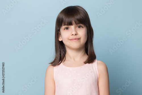 Adorable brown-eyed brown-haired little girl isolated on blue