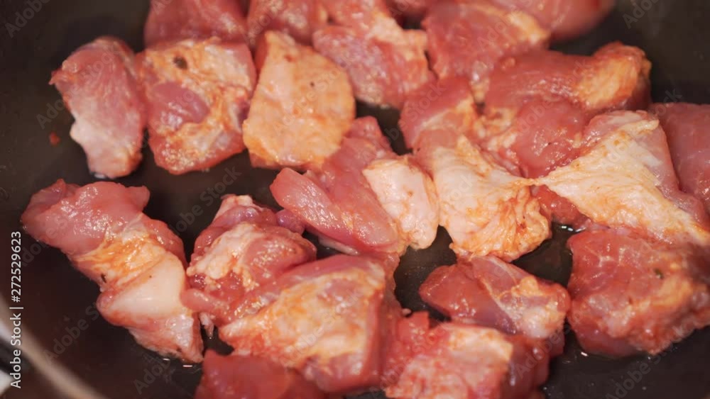 Cook prepares fried pieces of pork in a pan in the kitchen, close-up. Frying tasty and appetizing meat. Cook prepares fried pieces of pork in a pan in the kitchen, close-up. Frying tasty and appetizing meat.