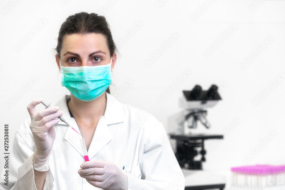 Cheerful female scientist with protective mask posing at the laboratory . Cheerful female scientist with protective mask posing at the laboratory .