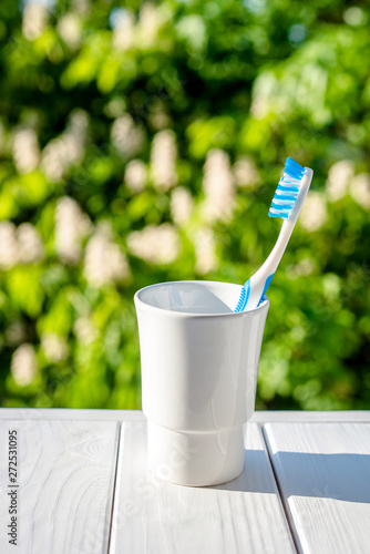 Toothbrush stands in a glass on a natural background 
