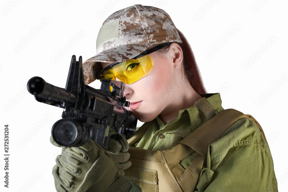 Fototapeta premium Beautiful young soldier woman in military uniform aiming at the enemy with automatic rifle M16, close up, isolated photo.