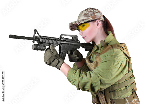Young soldier woman aiming at the enemy with automatic rifle.