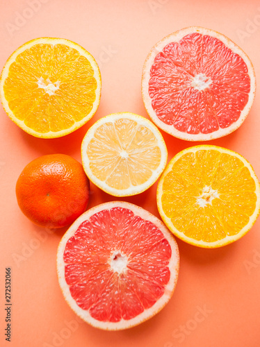 Flat lay of cut ripe juicy grapefruit  lemon and orange on orange color background.