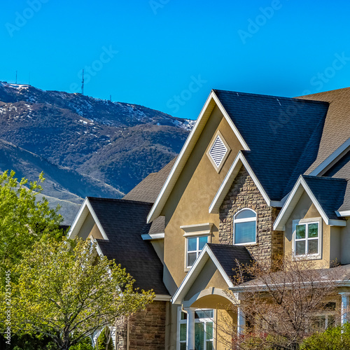 Square frame House exterior against mountain and blue sky viewed on a sunny day © Jason