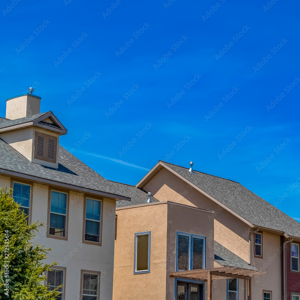 Square Exterior view of houses with vast blue sky background on a sunny day Square Exterior view of houses with vast blue sky background on a sunny day