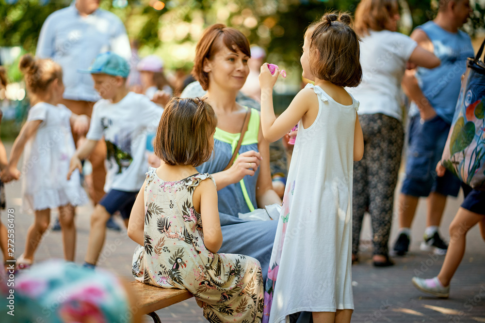 Fototapeta premium Portrait of mother and littles daughters at family picnic in the park.