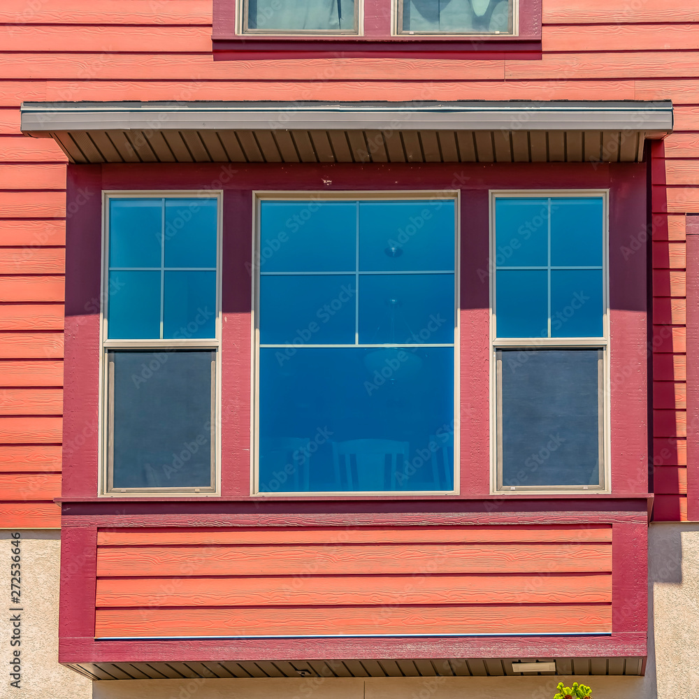 Square frame Window of a home with combination of wood section and neutral exterior wall