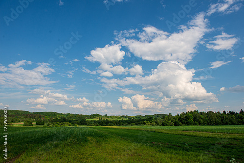 blue sky with white clouds over countryside landscape