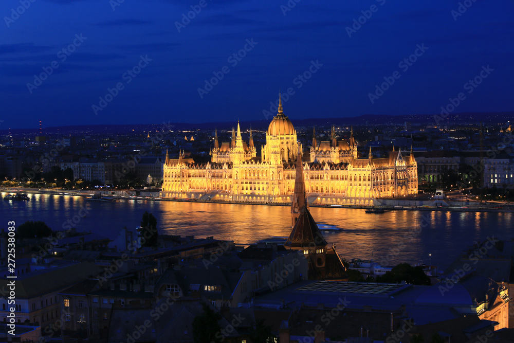 Beautiful night view of the Hungarian Parliament building and the Danube river with lights in the water in Budapest, Hungary