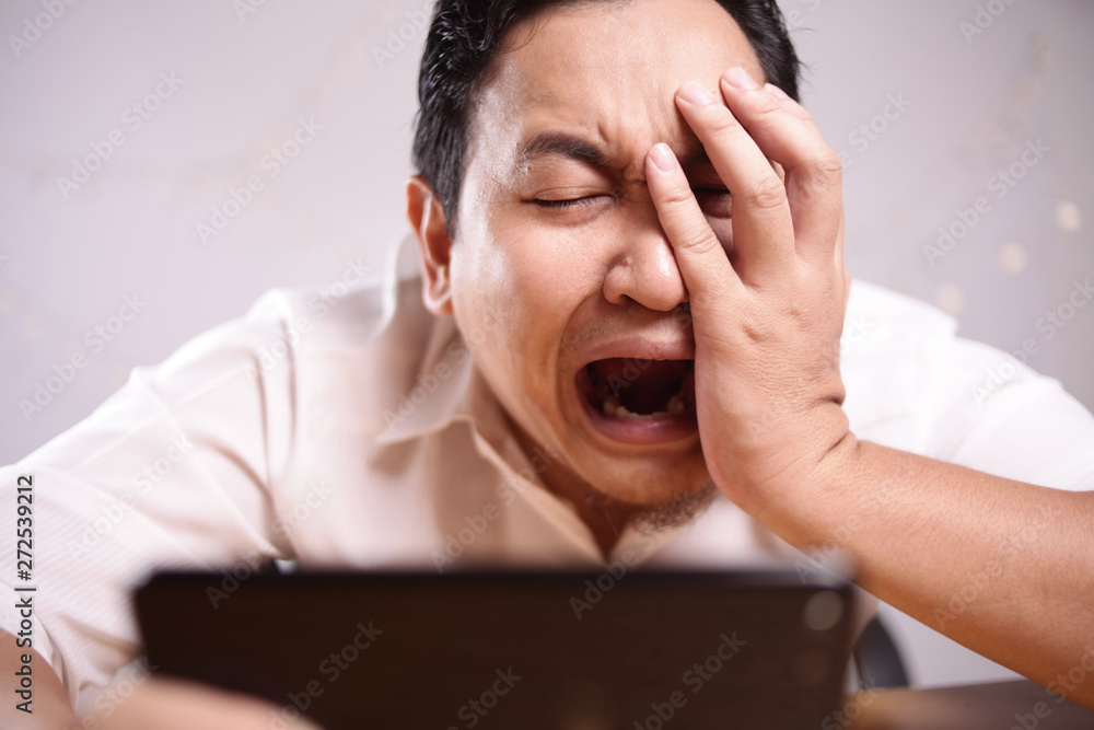 Funny Young Asian Guy Playing Games on Tablet Funny Young Asian Guy Playing Games on Tablet