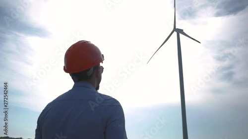 Male worker in helmet watching on the wind turbine	