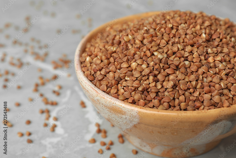Uncooked buckwheat in bowl on table, closeup Uncooked buckwheat in bowl on table, closeup