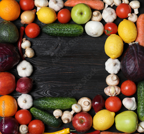 Frame made of fresh delicious vegetables and fruits on wooden table, flat lay. Space for text
