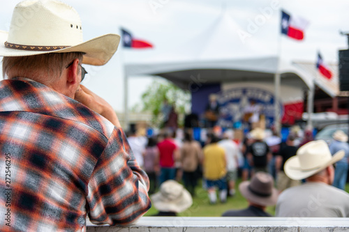 фотографія A spectator watches as Junior Brown and his band perform at a vintage car show near Austin, TX