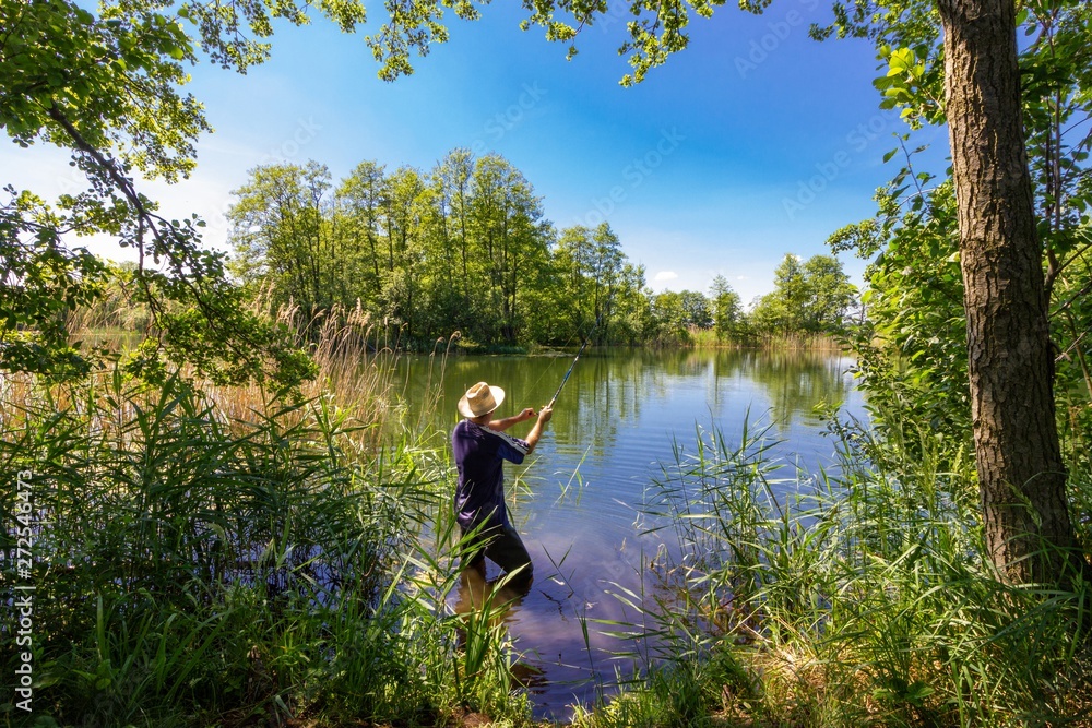 angler catching the fish during summer day