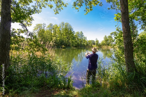 angler catching the fish during summer day © mtmmarek