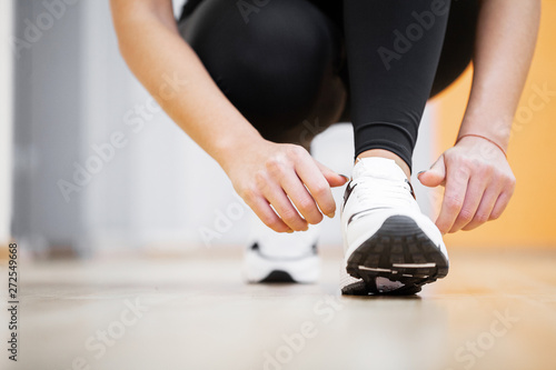 Fitness. Woman Runner Tightening Shoe Lace. Runner Woman Feet Running On Road Closeup On Shoe