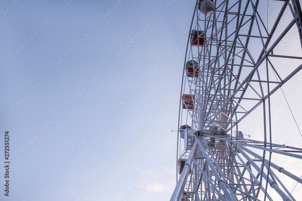 Ferris wheel. Attraction against the blue sky.