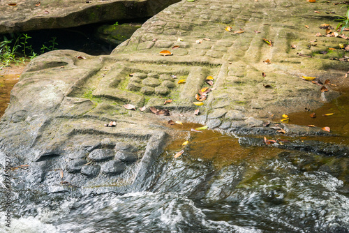 Group of sandstone Lingas (Symbol of Hindu god) shape like a lotuses at Kbal Spean waterfall on Kulen mountain range in Siem Reap, Cambodia. photo