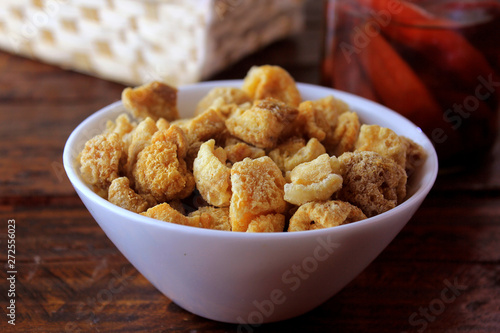 pork rinds fried in ceramic bowl on rustic wooden table in restaurant photo