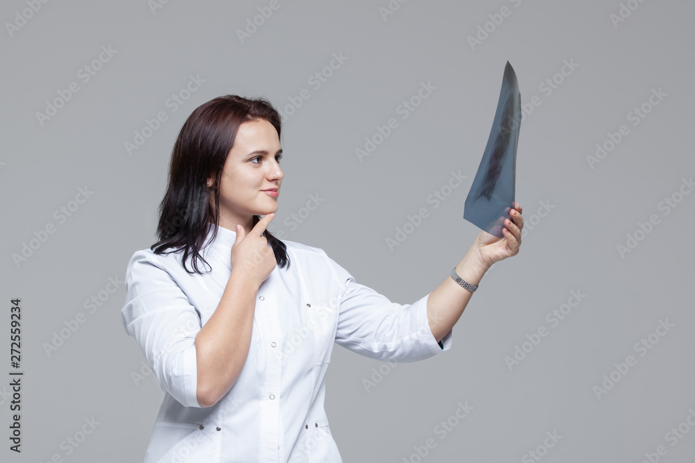 Young female doctor examining the x-ray picture of lungs Young female doctor examining the x-ray picture of lungs