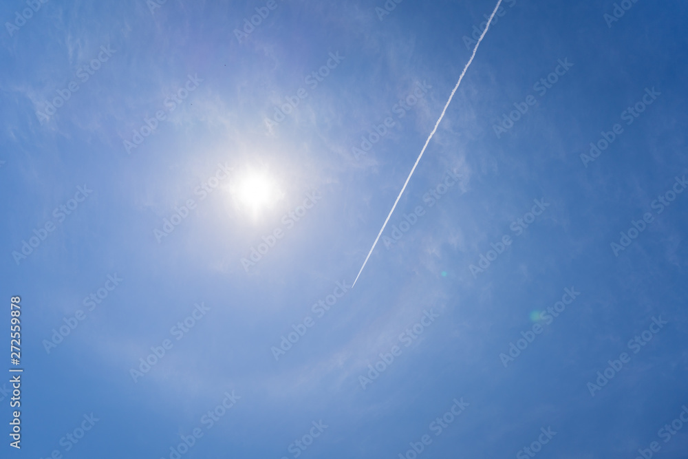 passenger plane flies across a blue sky leaving vapour trails passenger plane flies across a blue sky leaving vapour trails